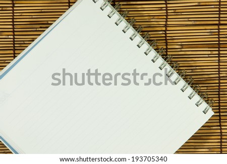 Open notebook with  white  on bamboo background