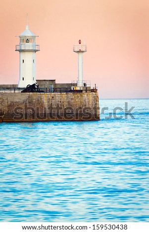 Seascape at sunrise. Lighthouse in the morning