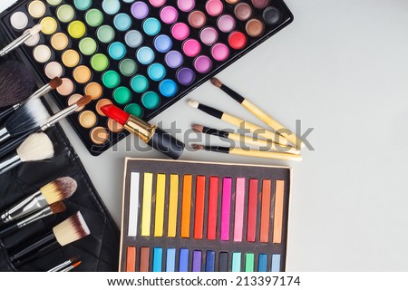 Overhead view of makeup cosmetics collection - lipstick, palette, professional makeup brushes etc