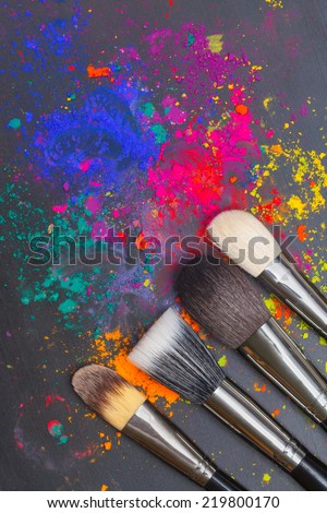 Makeup brushes with colorful powder. Beauty concept