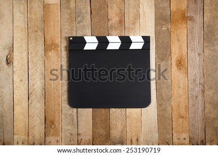 Movie production clapper board on a vintage wooden background