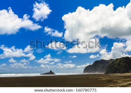 Summer Landscape with Rock in the Sea, Clouds and Blue Sky on the Tasman Sea Coast, Karekare Beach, Auckland Region, New Zealand