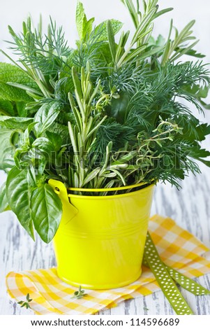 Fresh kitchen garden herbs in a decorative bucket.