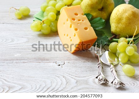 Delicious cheese and fruits on a wooden board. Food ingredients background. Selective focus.