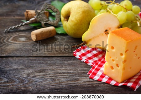 Wine frame background. Cheese and fruit on a wooden board.