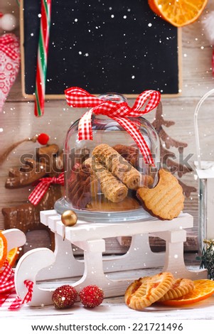 Christmas cookies in a glass bell jar on a decorative sledge.
