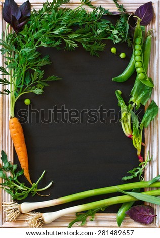 Vegetables garden frame with copy space for text. Fresh carrot, garlic, basil, arugula and green peas.