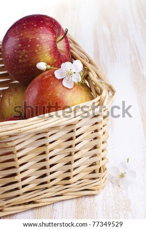 Red apples with flowers in the basket