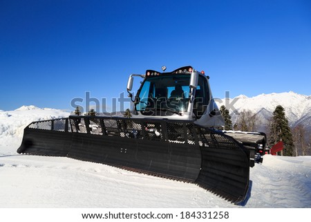 Snow-grooming machine on snow hill ready for skiing slope preparations in Russian Krasnaya Polyana