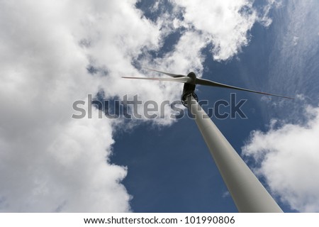 huge wind turbine or engine with three big wings on deep blue cloudy sky