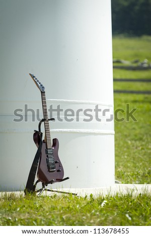 music guitar stands in carrier in front of a big steel column with grass around