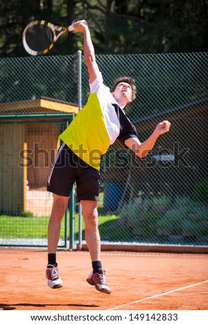 tennis player hits ball on highest point to serve