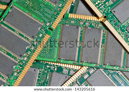 pile of computer memory chips on green printed circuit boards