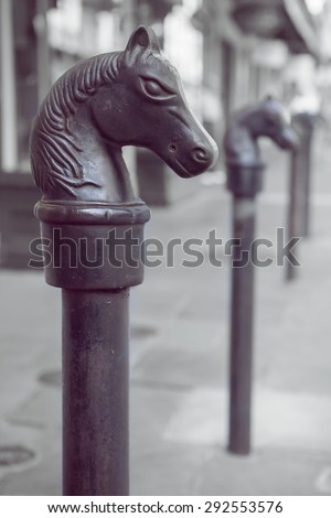 Antique horse head hitching post in the New Orleans French Quarter with shallow depth of field and retro filter effect