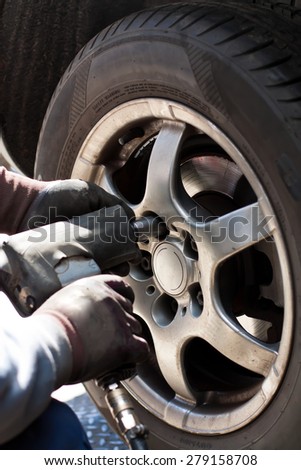 Removing the wheel of a car in the automobile repair shop.