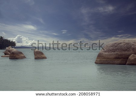 Group of Rocks on the Beach under a deep blue sky