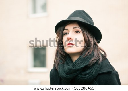 beautiful girl in a black hat and a black scarf the outdoor. Close-up portrait.
