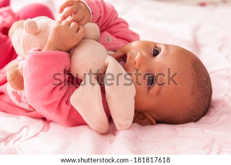 Adorable little african american baby girl playing with a plush - Black people