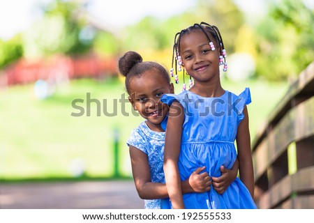Outdoor  portrait of a cute young black sisters smiling - African people - African people
