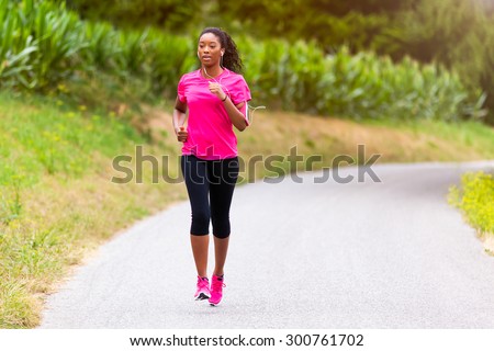 African american woman runner jogging outdoors - Fitness, people and healthy lifestyle