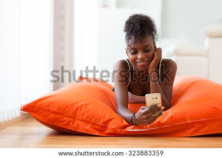 African American woman sending a text message on a mobile phone - Black people