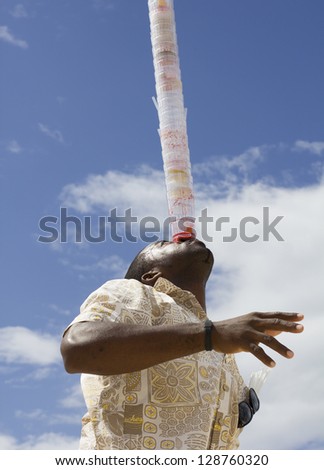 jamaican waiter making impressive move over blue sky