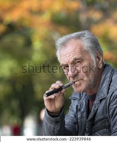 confident old man smoking an electronic cigarette