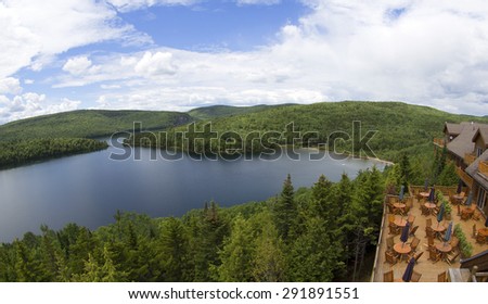 wooden terrace facing a lake in the middle of the forest