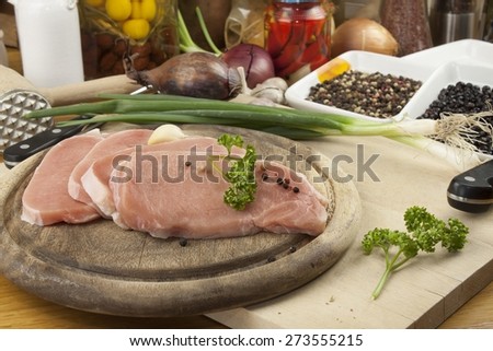 Home food preparation in the kitchen, roast pork on grill, Raw pork on cutting board and vegetables