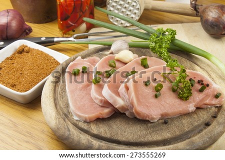 Home food preparation in the kitchen, roast pork on grill, Raw pork on cutting board and vegetables