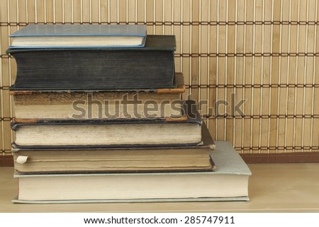 Front view of old books stacked on a shelf. Books without title and author.