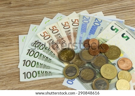 Euro coins and banknotes on the table. Detailed view of the legal tender of the European Union, EU. The uncertain future of the euro.