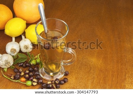 Traditional home treatment for colds and flu. Rosehip tea, garlic, honey and citrus. Hot tea with honey and lemon on a wooden tabletop. Home Pharmacy.