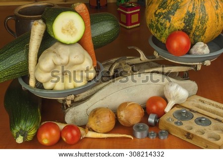 Growing vegetables in the organic farm. Vegetables grown in a small home garden. Old metal weight on homemade food. Background with vegetables. Promotion of healthy diets, diet food preparation.