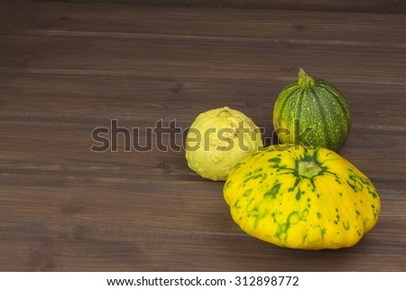 Autumn harvest of pumpkins. Preparing for Halloween. Growing vegetables in a home garden. Place for your text. Autumn pumpkins with leaves on wooden board