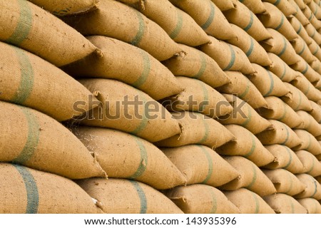 Old hemp sacks containing rice placed profoundly stacked in a row to keep up.