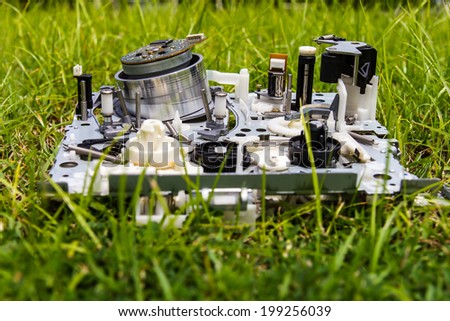 Mechanism of video tapes were discarded as trash laying on the grass.