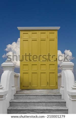 Yellow wooden door ,white columns, marble stairs ,Clouds, sky