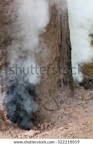 Close-up of smoke pouring out of the vent holes of traditional charcoal clay oven of Thailand.