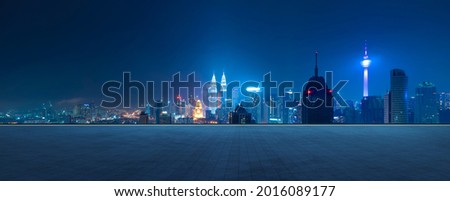 Photo of Panoramic view of empty concrete tiles floor with city skyline. Night scene.