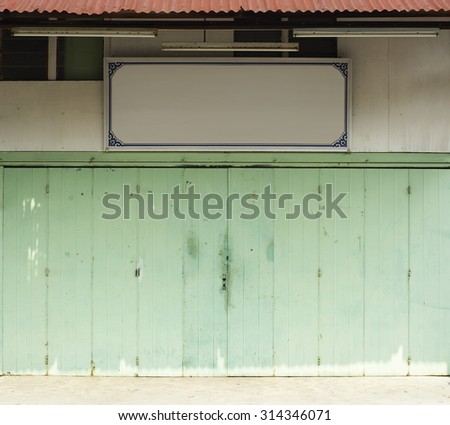 Vintage green door of chinese shop with empty Signboard