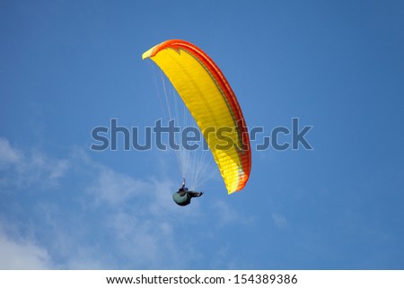 flying paraglider in blue sky