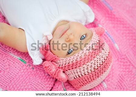 Charming child. Little girl in white knitted bear hat
