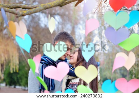man and woman kiss on Valentine\'s Day, the decor of hearts.