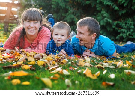 Happy family on walk in autumn park.