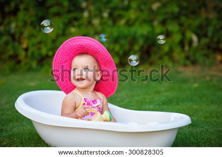 little girl in a red hat bathed in the bath.