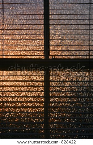 sunset through frosted window and blind