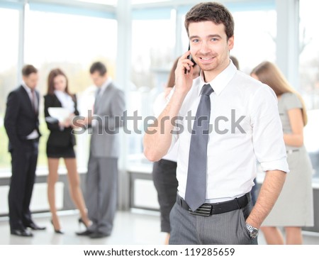 A young handsome business man on phone at office building