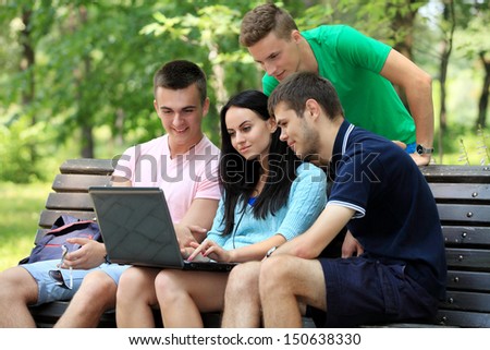 four smiling student studying in green park