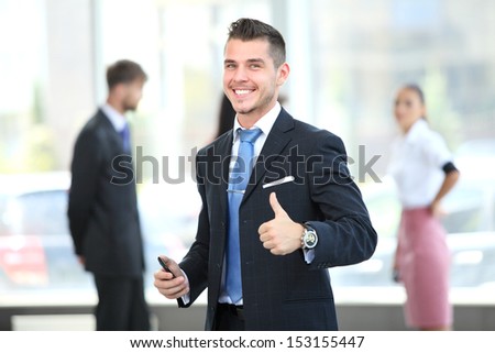 Happy smiling young business man with thumbs up gesture